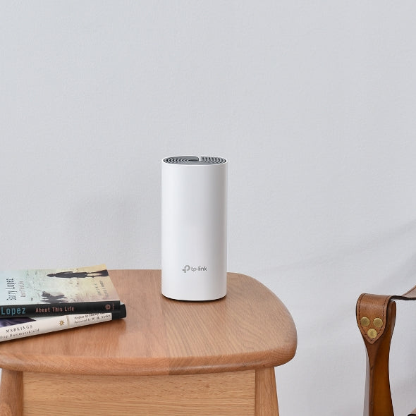 TP-Link Deco E4 AC1200 Whole Home Mesh Wi-Fi System (3 Pack) (TL-DECO E4) on a table, ensuring strong Wi-Fi coverage.